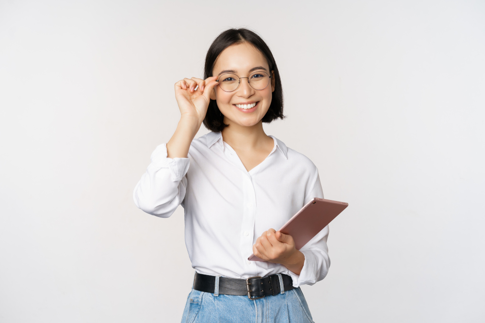 Image of young asian business woman, female entrepreneur in glasses, holding tablet and looking professional in glasses, white background